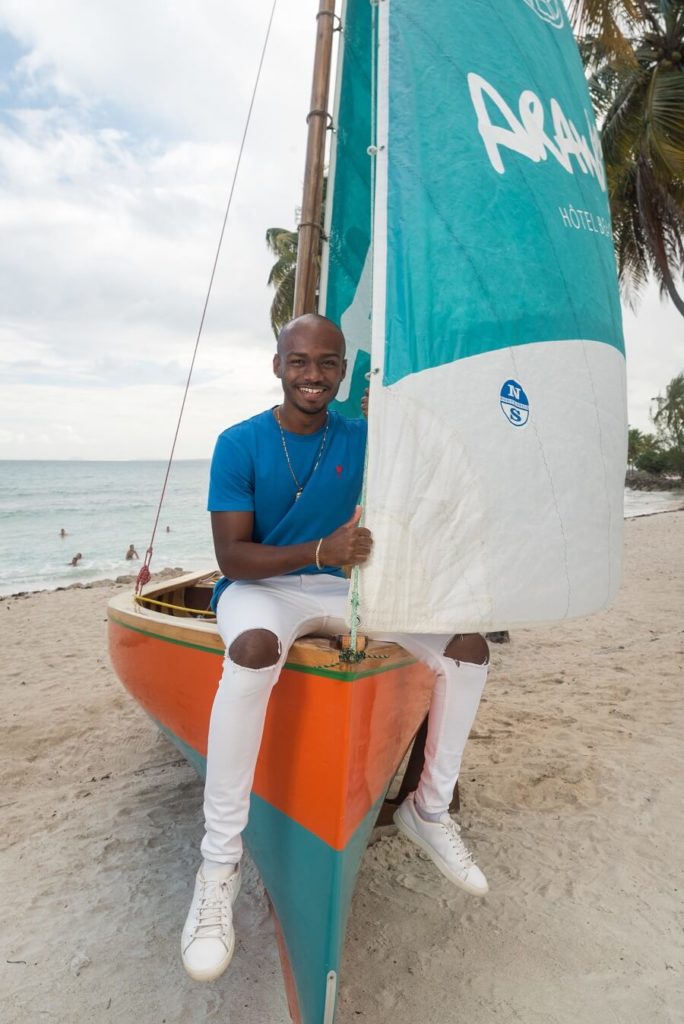 Krys assis sur un canot de voile traditionnelle