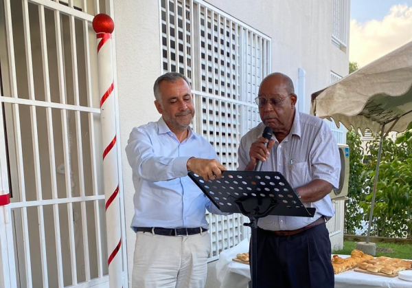 Deux hommes signent une convention lors d’un événement festif organisé en extérieur, décoré pour les fêtes.