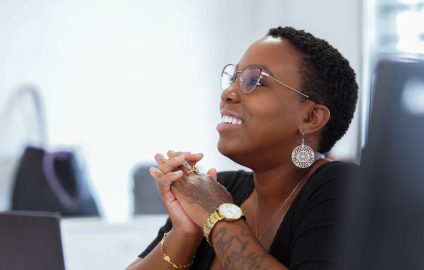 Mayat Charleton-Guitteaud, souriante, en réunion, assise devant un ordinateur portable