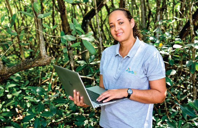 Catherine Hermant dans la mangrove, ordinateur à la main.