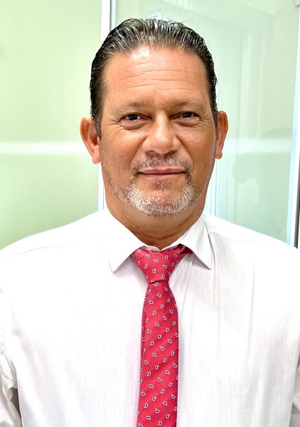 Adrien Baron, 1er vice-président chargé du développement économique à la CANBT, en chemise blanche et cravate rouge, posant dans un bureau lumineux.