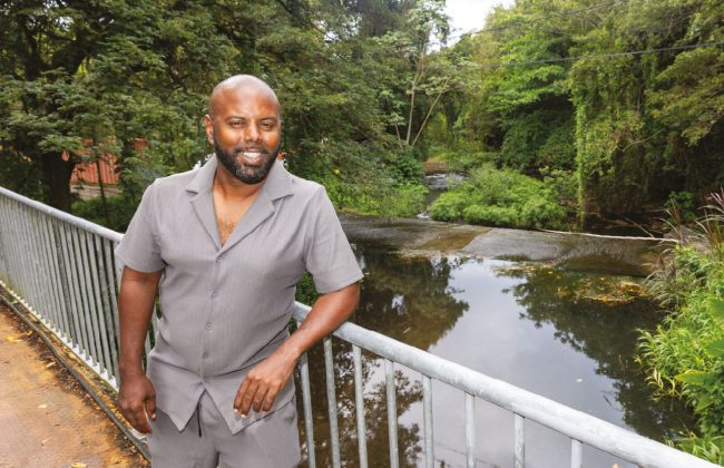 David Desnel, chef de projet chlordécone à la FDAAPPMA, debout sur un pont au-dessus d’une rivière bordée de végétation dense en Martinique.
