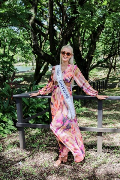 Victoria Kjaer Theilvig, Miss Univers 2024, vêtue d'une robe colorée et de son écharpe, appuyée contre une rambarde à l'habitation Clément en Martinique, une photo de Ludovic Lisee