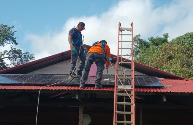 Installation et nettoyage des panneaux solaires sur le toit d'un carbet au village de Kayodé, situé au sud-ouest de la Guyane sur les rives de la rivière Tampoc.